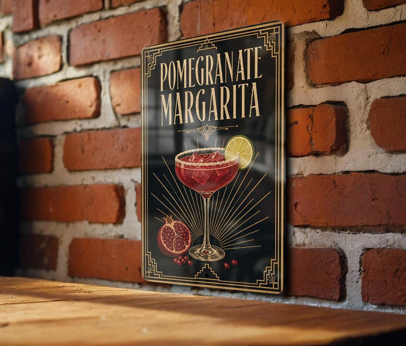 A decorative sign for a pomegranate margarita cocktail, featuring a glass of the drink and garnished with a lemon slice.