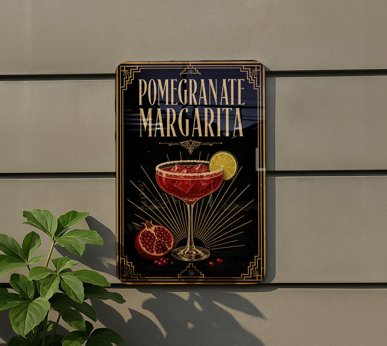 A decorative sign for a pomegranate margarita cocktail, featuring a glass of the drink and garnished with pomegranate seeds and a lemon slice.