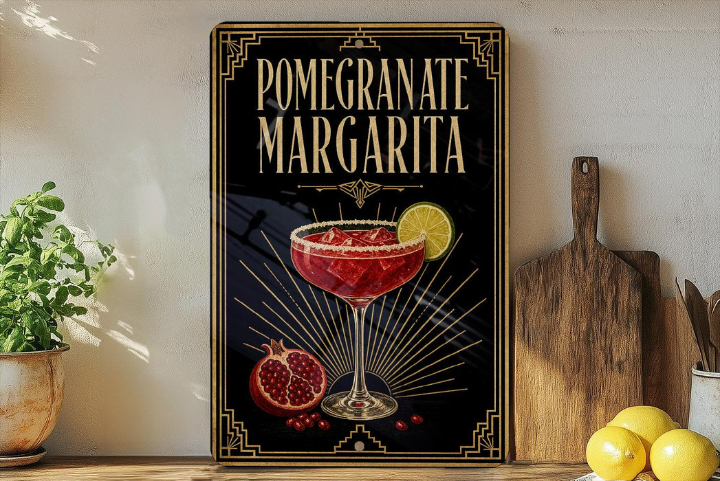 A framed poster of a pomegranate margarita is displayed on a wall, with a wooden cutting board and a potted plant to the side.