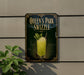 A sign for "Queen's Park Swizzle" is displayed on a wall, featuring a glass of a yellow-colored drink with a green leaf garnish.