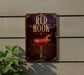 A sign for "Red Hook" cocktail, featuring a glass of red cocktail with a cherry on top, is displayed on a wall.