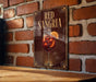 A sign for "Red Sangria" is displayed on a brick wall, featuring an illustration of a glass of red wine with a slice of orange.