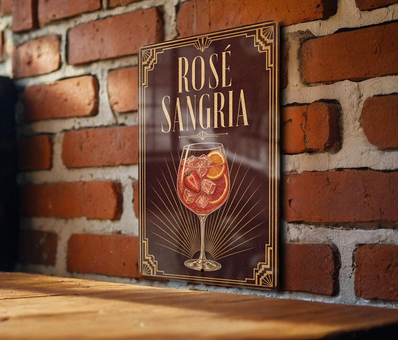 A sign with the text "ROSÉ SANGRIA" and an illustration of a glass of rose-colored wine against a brick wall background.