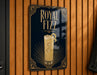 A sign for Royal Fizz cocktail, featuring an illustration of a tall glass filled with a yellow drink and garnished with a lemon slice.