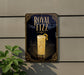 A sign for Royal Fizz cocktail is displayed on a wall, featuring an illustration of a cocktail glass with a lemon twist.