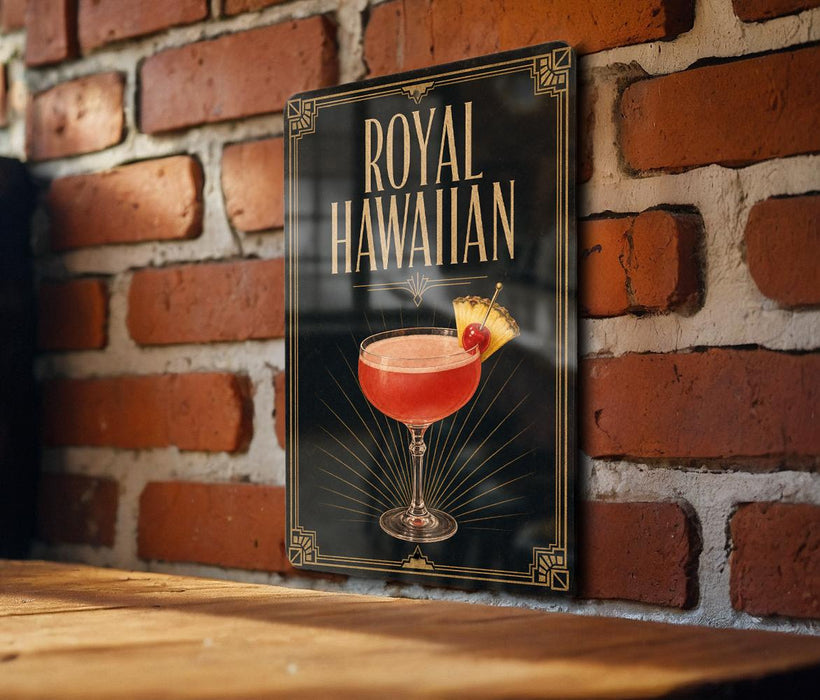 A framed poster of a Royal Hawaiian cocktail is displayed on a brick wall.