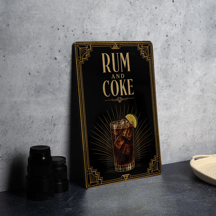 a framed advertisement for rum and coke, with a glass of the beverage and a lime slice on the side.