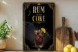 a poster with the text "RUM AND COKE" and an illustration of a glass of rum and coke with a lime slice.