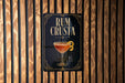 a sign with the text "RUM CRUSTA" and an illustration of a cocktail glass.