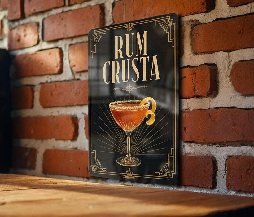 A sign with the text "RUM CRUSTA" and an illustration of a cocktail glass with a lemon peel.