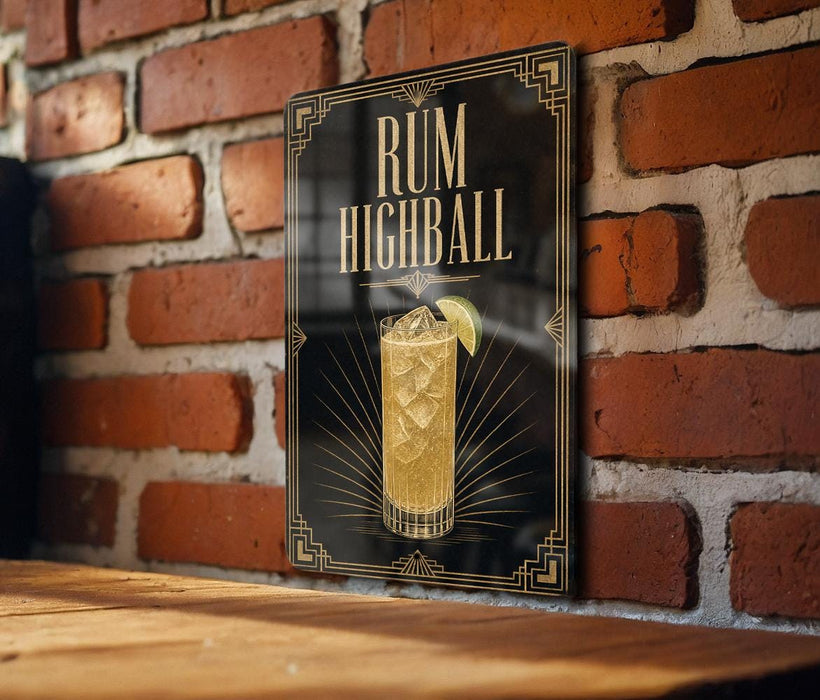 A framed poster of a rum highball cocktail is displayed on a brick wall.