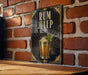 A framed poster of a rum julep cocktail is displayed on a brick wall.