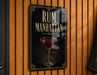 A sign that reads "RUM MANHATTAN" with an illustration of a glass of rum on a wooden wall.