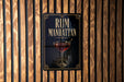 A sign for "RUM MANHATTAN" is displayed on a wooden wall.