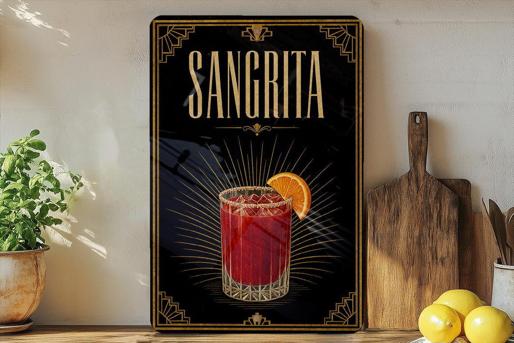A framed poster of a Sangrita cocktail is displayed on a wall, with a wooden cutting board and a potted plant to the side.