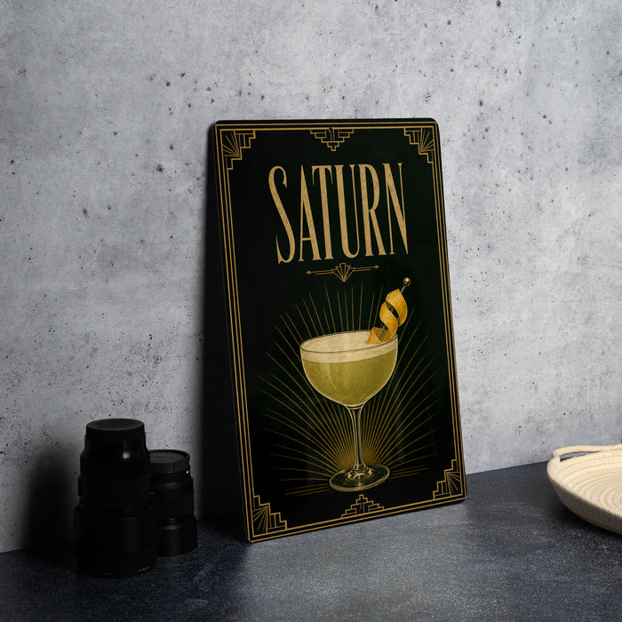 a framed poster or artwork with the word "SATURN" prominently displayed, along with an illustration of a cocktail glass and a lemon twist.