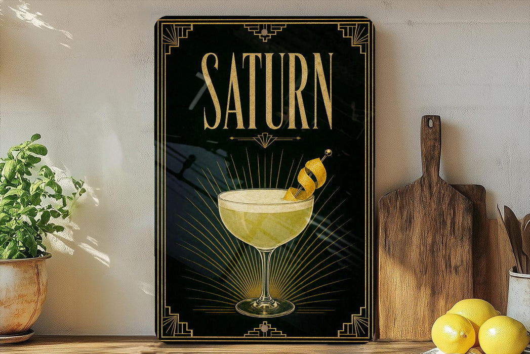 A framed poster of a cocktail called "Saturn" is displayed on a wall, with a lemon and a wooden cutting board visible to the right.