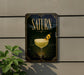 A framed poster with the word "SATURN" prominently displayed, featuring an illustration of a cocktail glass with a lemon twist.