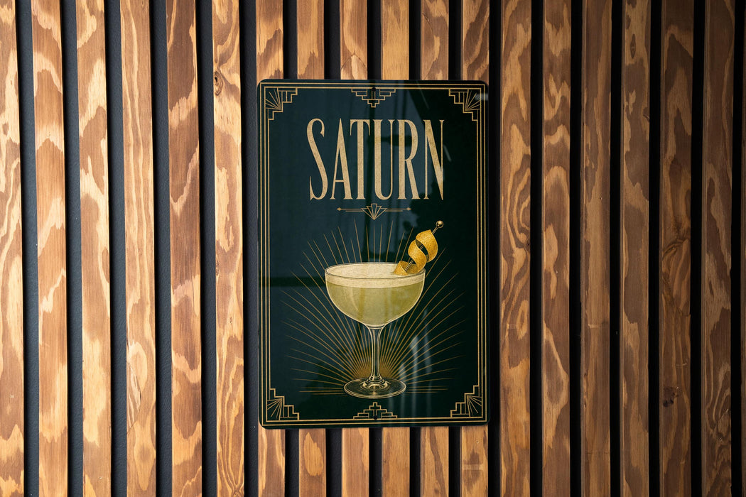 A poster with the word "SATURN" displayed prominently, featuring an illustration of a cocktail glass with a lemon twist.