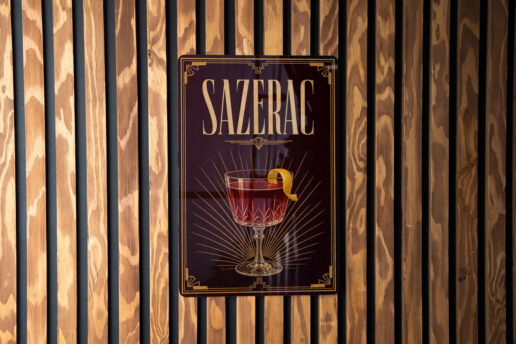A poster with the word "SAZERAC" prominently displayed, featuring an illustration of a glass of red wine with a lemon peel.