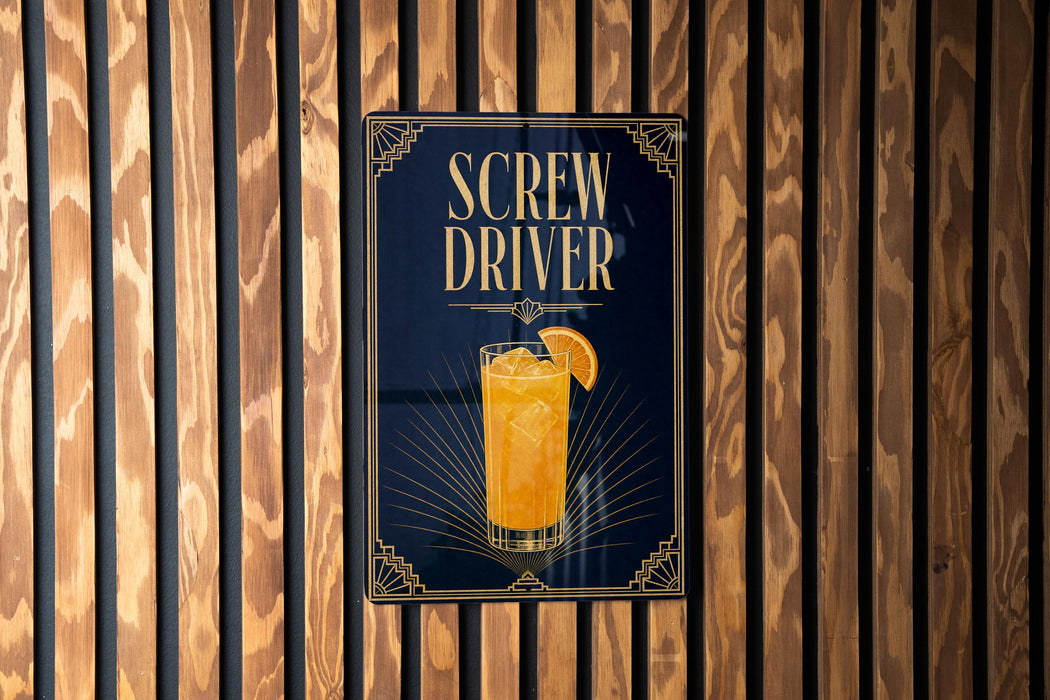 A sign for a Screw Driver cocktail is displayed on a wooden wall.