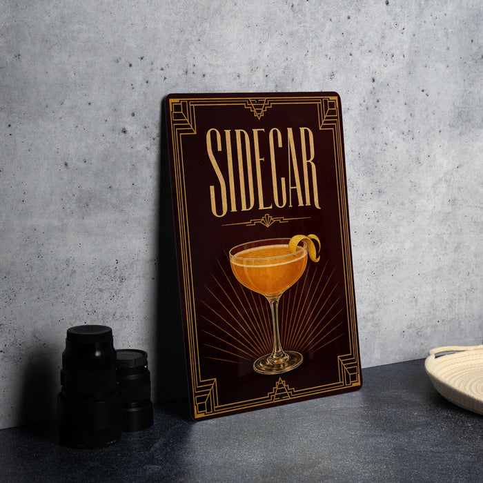 A framed poster or sign with the word "SIDECAR" prominently displayed, featuring an illustration of a cocktail glass with a lemon twist.