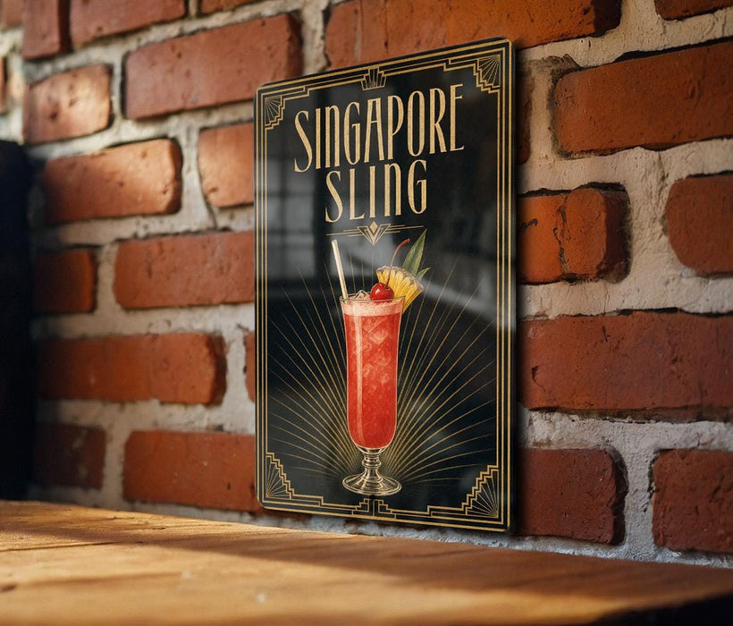 A framed poster of a cocktail called "Singapore Sliding" is displayed on a brick wall.