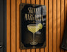 A sign for a skinny margarita cocktail is displayed on a wooden wall.