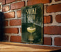 A green sign with gold lettering that reads "SMOKE SHOW" is displayed on a brick wall.