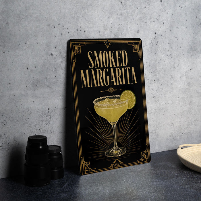 A framed poster or sign advertising a "Smoked Margarita" cocktail, featuring an illustration of a margarita glass with a slice of lime.