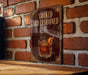 A sign with the text "SMOKED OLD FASHIONED" and an illustration of a glass of amber-colored liquid, possibly whiskey, with an orange slice garnish.