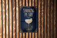 A poster with the title "Smoking Pearl" is displayed on a wooden wall.