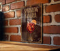 A sign for "Sparkling Sangria" is displayed on a brick wall, featuring an illustration of a glass filled with a red drink and a slice of orange.