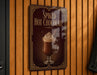 A sign advertising "Spiked Hot Chocolate" is displayed on a wooden wall.