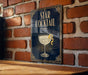 A framed poster of a cocktail glass with a star on it, mounted on a brick wall.