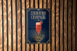 A poster advertising a strawberry champagne drink is displayed on a wooden wall.