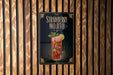 A poster advertising a strawberry mojito is displayed on a wooden wall.
