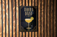 A sign for "Tequila Daisy" cocktail is displayed on a wooden wall.