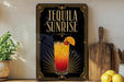 A framed advertisement for a tequila sunrise cocktail, featuring a colorful illustration of the drink and the text "TEQUILA SUNRISE" prominently displayed.