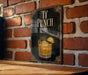 A sign with the text "T' PUNCH" and an illustration of a cocktail glass with a lime slice, mounted on a brick wall.