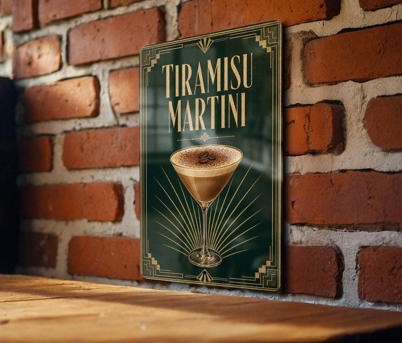 A framed poster of a tiramisu martini hangs on a brick wall, featuring an illustration of the cocktail and the text "Tiramisu Martini" prominently displayed.