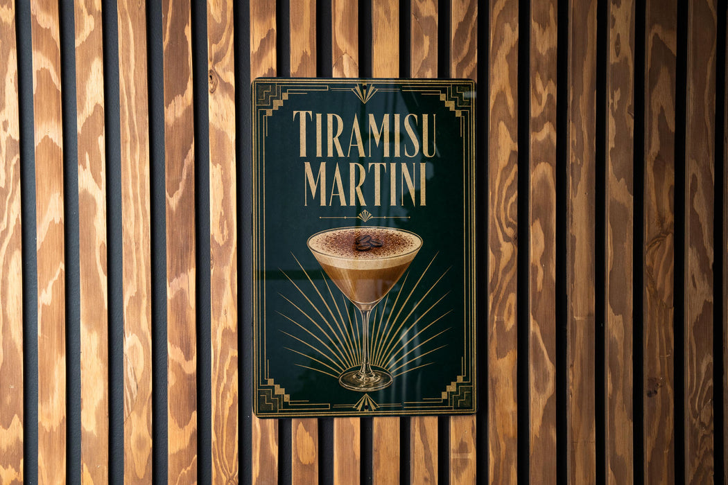 A framed poster of a tiramisu martini hanging on a wooden wall.