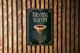 A framed poster of a tiramisu martini hanging on a wooden wall.