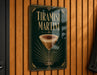 A metallic sign with the text "Tiramisu Martini" and an illustration of a cocktail glass with a frothy top.