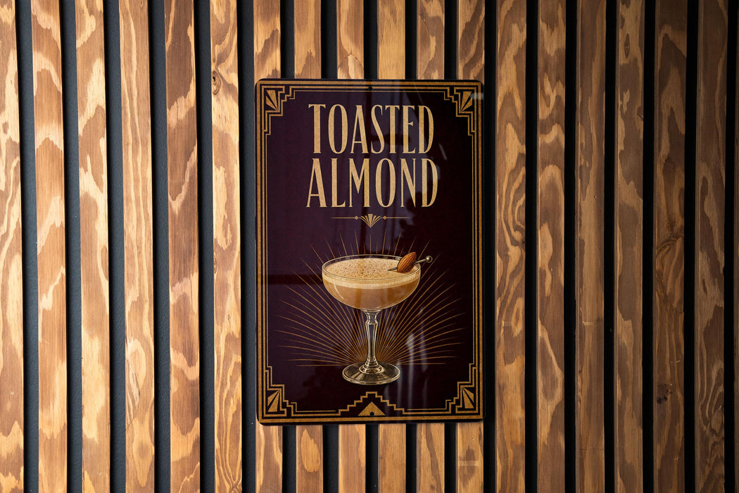 A sign for "Toasted Almond" cocktail is displayed on a wooden wall.