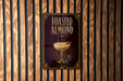 A sign for "Toasted Almond" cocktail is displayed on a wooden wall.