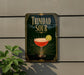 A sign for "Trinidad Sour" cocktail, featuring a glass of the drink with a lemon slice on the rim.