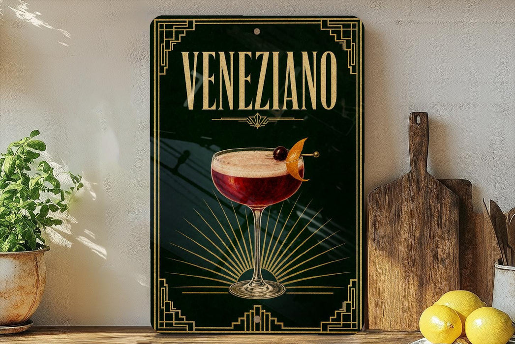 a decorative sign with the word "Veneziano" prominently displayed, along with an illustration of a cocktail glass and garnish. The sign is placed on a wooden surface, with a potted plant, a cutting board, and some lemons nearby.
