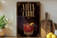 a decorative sign with the text "VIEUX CARRE" and an illustration of a cocktail glass with a lemon slice.