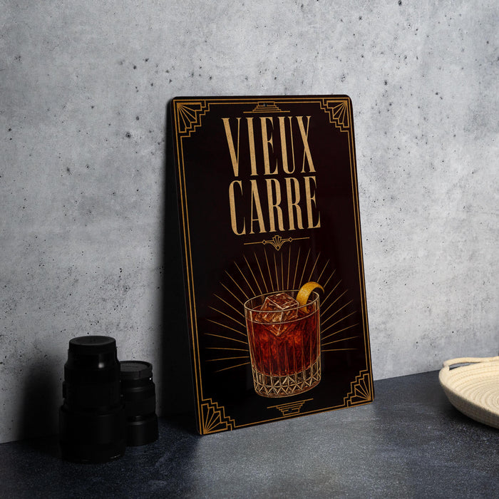 a decorative sign with the text "VIEUX CARRÉ" and an illustration of a cocktail glass with ice cubes and a lemon slice.